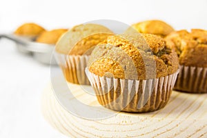 Freshly Baked Homemade Whole Wheat Bran Carrot Pumpkin Muffins on Wooden Board. Breakfast Morning Sunlight. Healthy Pastry Baking