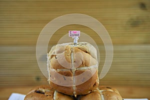 Freshly baked hot cross buns with miniature person figurine with sign indicating i love Easter