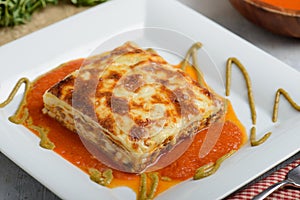 Freshly baked lasagna on white plate