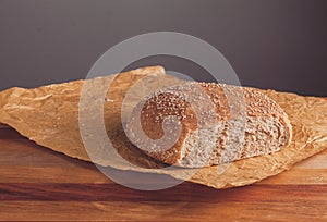 Freshly baked loaf of wholemeal bread with bran on baking paper