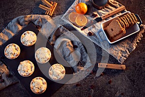 Freshly Baked Mince Pies And Cookies On Table Set For Christmas With Cinnamon Sticks And Orange