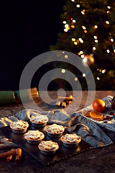 Freshly Baked Mince Pies On Table Set For Christmas With Tree Lights In Background