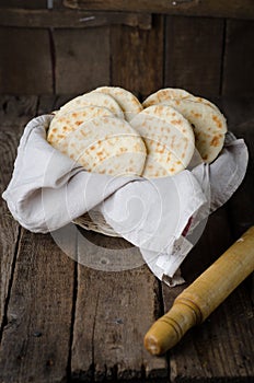 Freshly baked Moroccan mini flatbread - batbouts on wooden table. Selective focus. Arabian food