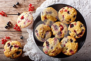 Freshly baked muffins with black and red currant berries close-up. Horizontal top view from above