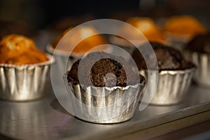 Freshly baked muffins in metal molds close-ups in a bakery.