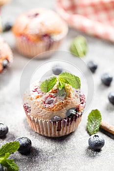 Freshly baked muffins with powdered sugar and fresh berries