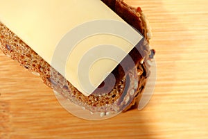 Freshly baked multi-grain bread with cheese on wooden background