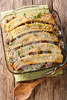 Freshly baked pastelon de Platano Maduro casserole close-up in a baking dish. Vertical top view photo