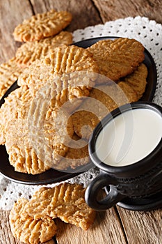 Freshly baked peanut butter cookies with a cup of milk close-up. vertical