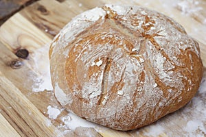 Freshly baked pot bread on a bread board.