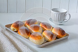 Freshly baked ruddy buns on a white tray