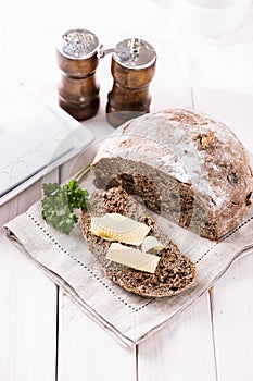 Freshly baked rye bread cob over white wooden background