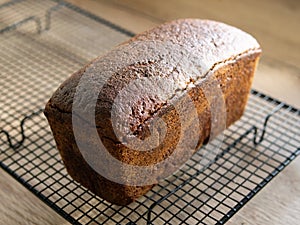 Freshly baked rye bread cools down on a metal grate. soft daylight. Horizontal. Close up, copy space