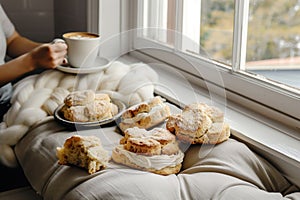 freshly baked scones, person with latte, soft cushioned window seat