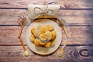 Freshly baked scones on a wooden plate with different spices on