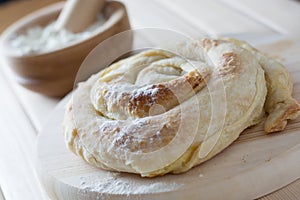 Freshly baked spiral cheese pie on the wooden plate