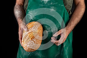 Freshly baked tasty bread in the baker& x27;s hands. Tasty baked goods straight from the bakery