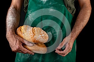 Freshly baked tasty bread in the baker& x27;s hands. Tasty baked goods straight from the bakery