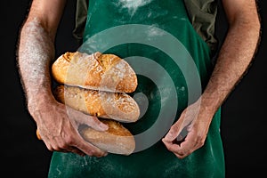 Freshly baked tasty bread in the baker& x27;s hands. Tasty baked goods straight from the bakery