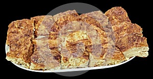 Freshly Baked Traditional Serbian Crumpled Cheese Pie Gibanica Served on Oval Ceramic Tray Isolated on Black Background