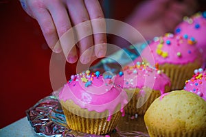 Freshly baked vanilla muffins are garnished with sweet icing and topping.