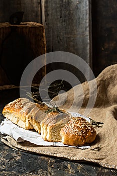 Freshly baked wheat bread on natural linen napkin and bag. Homemade bakery. Still life of bread. Slice of gold rustic crusty loave