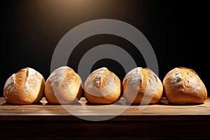 Freshly baked white wheat bread loaves on table on dark background. With copy space. Ideal for food blog, advertising