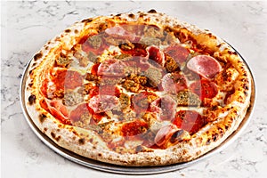 Classic meatlovers pizza on a gray marbled surface