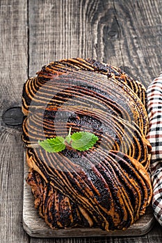 Freshly baked yeast poppy seed roll on wooden table