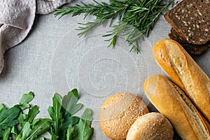 Freshly bakes bread, herbs and greens on a table, overhead flat lay