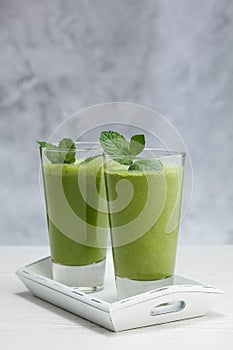 Freshly blended green fruit smoothie in glass