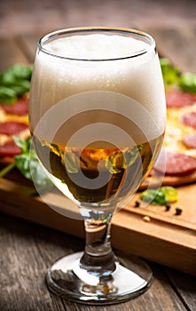 Freshly brewed beer and pepperoni pizza in bar