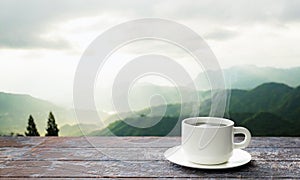 Freshly brewed coffee or espresso into a white coffee mug. Hot coffee in a mug placed on the tabletop or wooden balcony. Morning