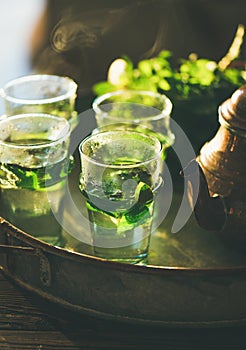 Freshly brewed mint Moroccan tea with herb leaves in glasses