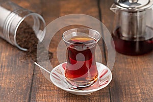 Freshly brewed turkish tea in thin-waisted glass cup on wooden table