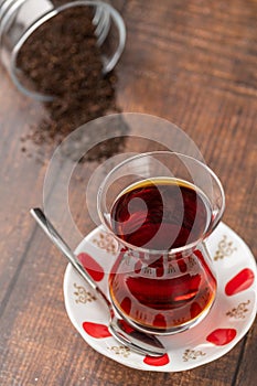 Freshly brewed turkish tea in thin-waisted glass cup on wooden table