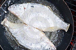 Freshly caught fish is fried in a pan in oil