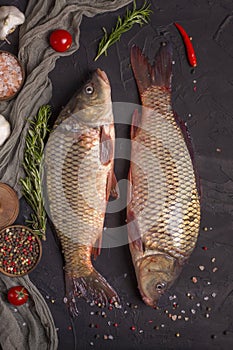 Freshly caught two carps with scales, ready to cook on a wooden board. Top view, copy space