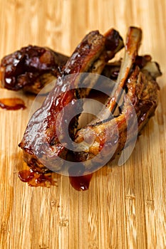 Freshly cooked BBQ ribs with sauce on wooden board