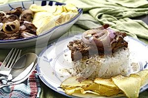 Bistek Tagalog or fried pork tenderloin in soy sauce with potato chips photo