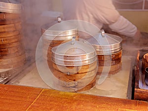 Freshly cooked steamed buns and dumplings for sale in Yuyuan garden, Shanghai, stacks of bamboo food steamer with wihte vapor