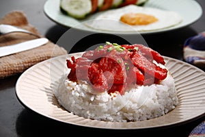 Freshly cooked Tocino or cured pork meat served with fried rice and egg with vegetables