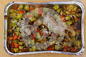 Freshly cooked vegetables, mushrooms and meat in a foil container