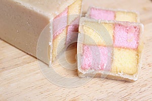 Freshly cut Battenberg Cake with pink and yellow sponge covered in marzipan