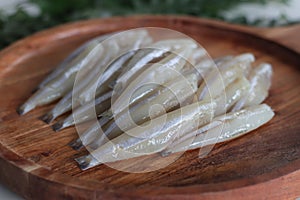 Freshly cut and cleaned anchovy fish presented on a rustic wooden tray photo
