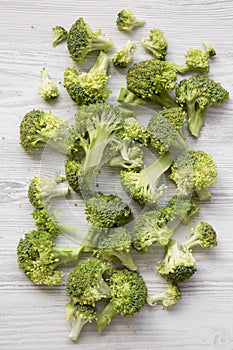 Freshly cut raw broccoli on white wooden table, top view. Overhead