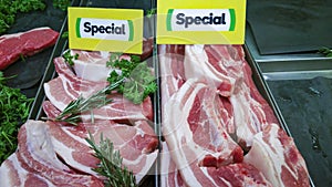 Freshly cut raw pork slices on retail display for sale in the local butchery