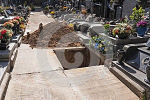 A freshly dug grave in the cemetery. Funeral preparation. Open grave in graveyard.