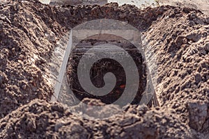 Freshly dug grave pit at cemetery, a close-up