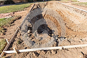 Freshly Dug Hole In Yard Preparing For Swimming Pool Installation